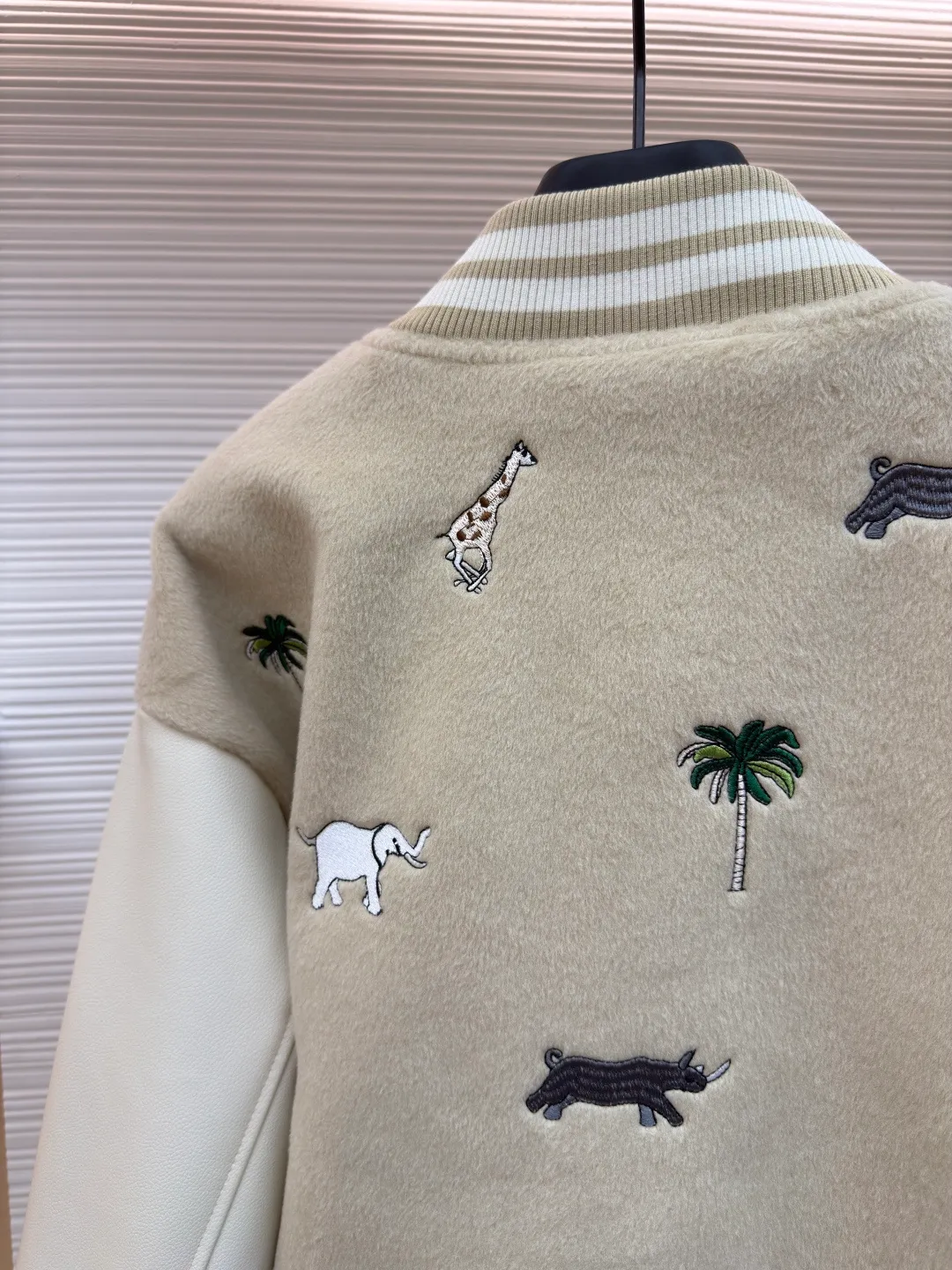 LOUIS VUITTON animal embroidered baseball uniform ●Original version: 48000 purchased and developed ●Item number: 1682284-B90 ●Fabric: cotton fabric ●Technology: embroidery production ●Color: apricot ●Version: fitted version ●Weight: about 1070 grams ●Size: 46-48-50-52 ●Description: The main body of this Louis Vuitton embroidered baseball jacket is made of high-quality wool blended fabric, which is crisp and soft. The sleeves are made of eco-friendly artificial leather with a matte texture, which contrasts with the body in terms of material and touch. The animal, palm tree and other patterns on the body of the clothing are all completed by hand-stitched embroidery technology, using multi-color embroidery threads to embroider in layers. The patterns are three-dimensional and vivid, and the stitching in the details is fine and even. The letter logo uses flat embroidery technology, and the font outline is clear and regular. The ribbed collar, cuffs and hem of the jacket are made of high-elastic knitted fabric, which will not loosen easily after being worn for a long time. The metal snaps on the placket are custom-made hardware with a thick texture and anti-oxidation. The overall tailoring is a loose oversize version, and the splicing uses hemming stitching technology, and the lines are smooth and smooth. Every craft detail is in line with the brand's luxury product production standards, creating a ready-to-wear garment that has both a sense of design and practical wearability. The overall wiring is straight and delicate, the fabric is comfortable and soft, and the color is consistent without color difference. It can be matched with the same style to create a fashionable look and control various occasions. Customized accessories, complete with three standards, same style for men and women!